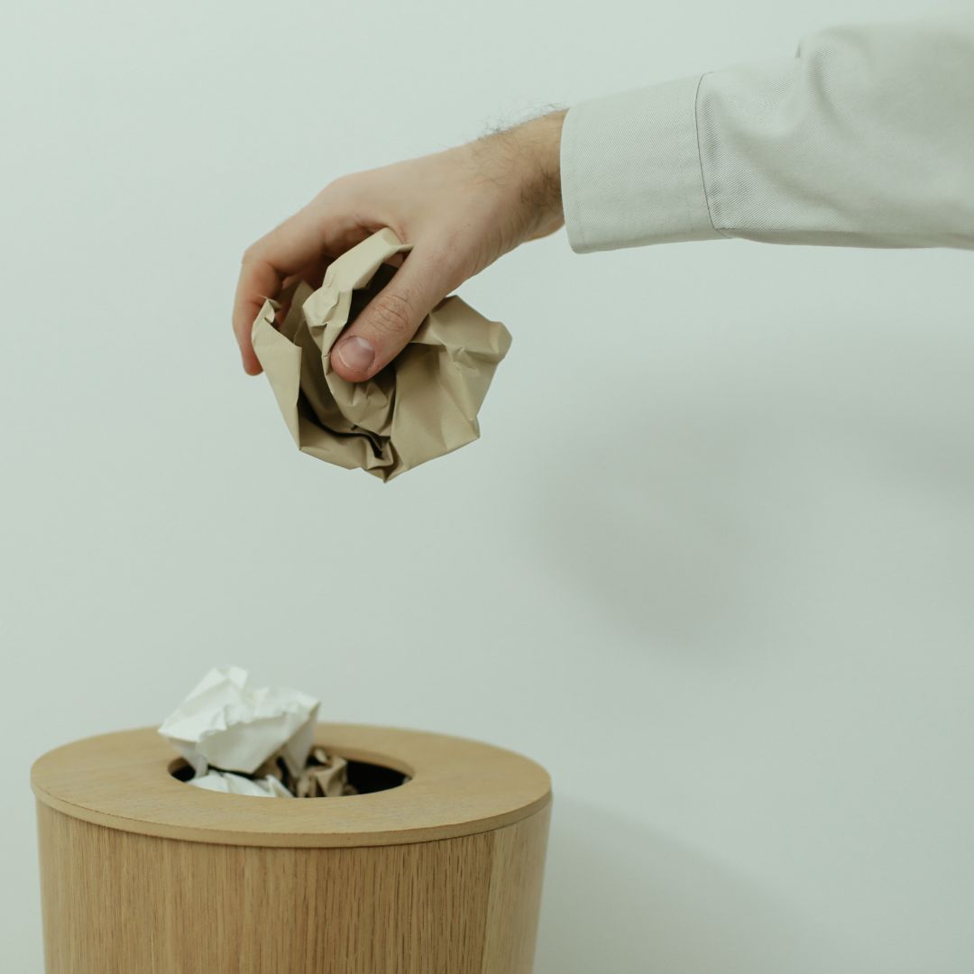 Throwing waste into a trash can.